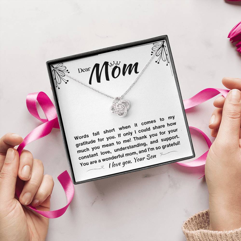 Two hands opening a Gift box with a silver necklace and a loving message for a mom.