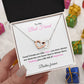 A necklace in a  gift box with a message to a best friend. hold by 
 woman hand in a decorative background. The necklace features two interlocking hearts, one silver and one rose gold. The message on the box reads: "To My Best Friend, Good Friends are Like Stars, you don't always see them but you know they're always there. Wishing you a life full of happiness. Besties forever."